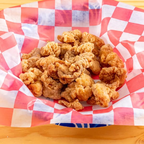 Golden-brown fried chicken bites served in a red and white checkered paper-lined basket.